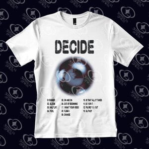 May include: White t-shirt featuring the word "DECIDE" in black above a circular graphic resembling an 8-ball. The graphic has the word "DECIDE" inside. Song titles are listed below. A casual tee for music lovers.
