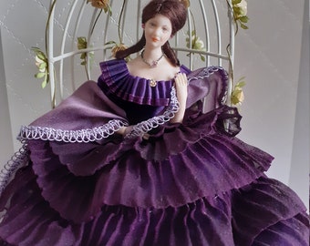 Porcelain doll in purple dress in garden seat