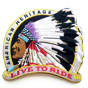 May include: Embroidered patch featuring a Native American wearing a headdress. The patch is white with a black circle in the centre. The circle has the text "American Heritage" around the outside and "Live to Ride" in a yellow banner at the bottom.