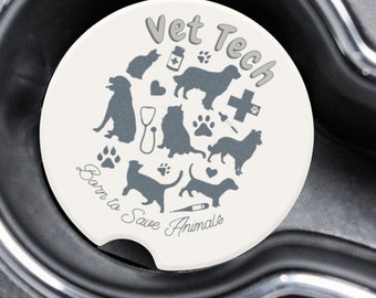 May include: Two white car coasters with a gray design. The coasters feature a circle of animal silhouettes and the text "Vet Tech Born to Save Animals".