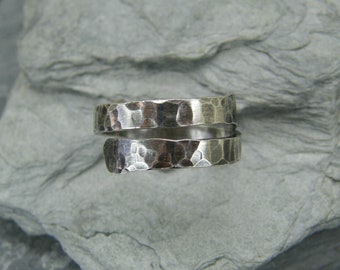 May include: A silver hammered metal ring with a twisted design.