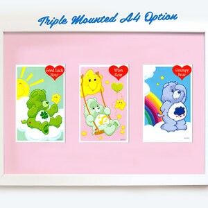 Pu&ograve; includere: Opzione di montaggio triplo A4 con tre carte Care Bear. Le carte presentano Good Luck Bear, Wish Bear e Grumpy Bear. Ogni carta presenta un'illustrazione colorata dell'orso su uno sfondo bianco.