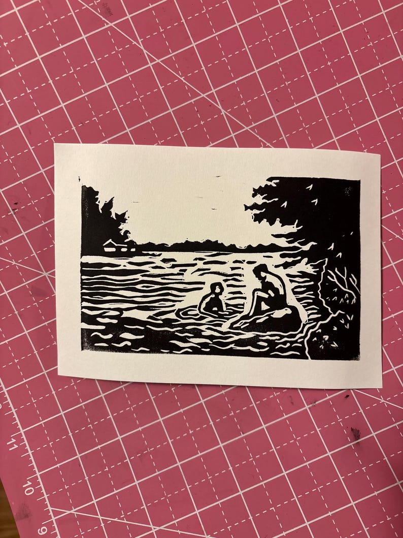 May include: A black and white linocut print depicting two figures in a lake or river. One figure is seated on a rock, while the other is in the water. Trees and water are also visible.