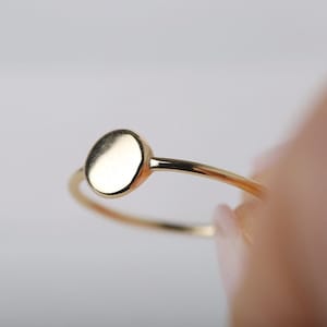 Peut inclure: Une bague en or simple avec un dessus rond et plat.
