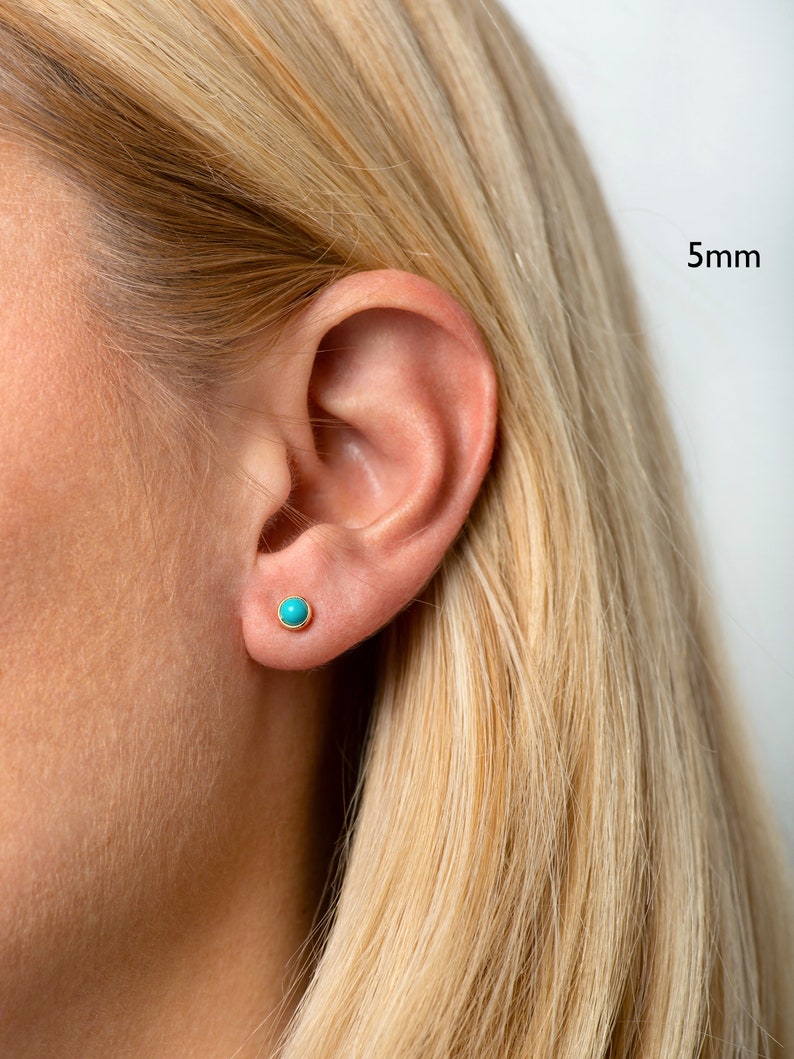 May include: A close-up of a person's ear with a small turquoise stud earring. The earring is 5mm in diameter.