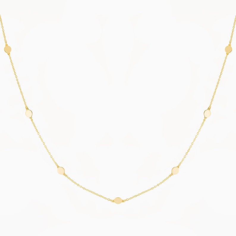 Puede incluir: Un collar de cadena de oro con peque&ntilde;os discos redondos espaciados uniformemente a lo largo de la cadena.