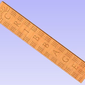 May include: A light brown wooden cribbage board with the word "CRIBBAGE" carved into the surface. The board has rows of holes for pegging scores. The board has a curved end and is angled.