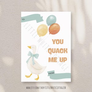 May include: A greeting card featuring a white goose illustration with a blue bow and balloons. The card has the text "You Quack Me Up" in orange. Includes space to write "To:" and "From:" on a white background.