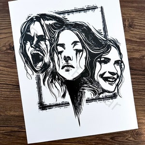 May include: Black and white art print depicting three faces, each expressing a different emotion: screaming, crying, and smiling. The artwork is framed by a textured, rectangular border, and the print is on white paper.