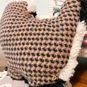 Pu&ograve; includere: Un cuscino a forma di cuore con un motivo rosa, nero e giallo con un bordo bianco e soffice.