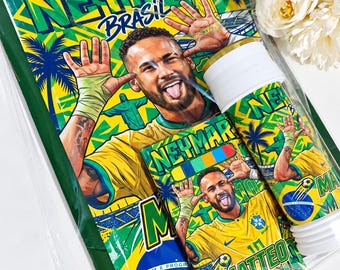 May include: A rectangular notebook and a cylindrical water bottle featuring a graphic print of Neymar in a yellow Brazil soccer jersey. The design includes the text NEYMAR, BRASIL, and MATTEO, along with palm trees, a soccer ball, and the Brazilian flag.