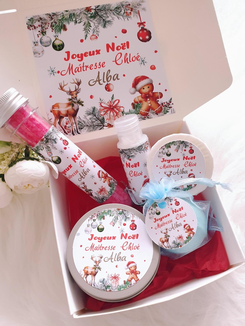 K&ouml;nnte beinhalten: Eine Geschenkbox mit weihnachtlichen Artikeln. Die Box enth&auml;lt eine Tube, eine Flasche, eine runde Dose und eine runde Seife, alle mit festlichen Designs. Die Box enth&auml;lt auch ein Etikett mit dem Text "Joyeux No&euml;l Maitresse Chlo&eacute; Alba."