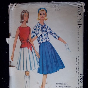 Puede incluir: Patrón de costura vintage McCall's para una falda plisada y una blusa. El patrón es para tallas de busto de 36 a 50 y está impreso en un fondo blanco con una ilustración en azul y blanco de dos mujeres que llevan las prendas. El texto en el patrón dice "McCall's 5700 Patrón impreso Blusas para mujeres y juniors y falda plisada en caja en dos longitudes Talla 36 Busto 50c En Canadá 60c Seventeen dice: "¡Es moda joven!"