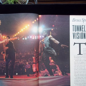 May include: A magazine page with a photo of Bruce Springsteen performing on stage with his band. The article is titled "Bruce Springsteen's Tunnel Vision" and discusses his music and career. The text in the article reads "After the monumental success of Born in the U.S.A., the reverberations of a hard-look album and a career dedicated to bringing for more hard drive is to human proportions."