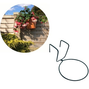 May include: Black metal plant hanger with a round ring and two hooks. The hanger is designed to hold a plant pot.