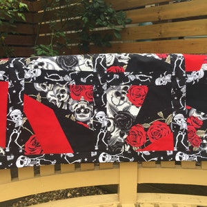 Könnte beinhalten: Eine schwarze und rote Patchwork-Decke mit einem Totenkopf- und Rosenmuster. Die Decke besteht aus verschiedenen Stoffen und hat eine Vielzahl von Designs.