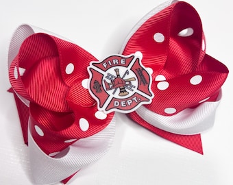 May include: Red and white polka dot hair bow with a fire department logo in the center. The logo is a red cross with a fireman's helmet, axe, ladder, and fire hydrant. The text "FIRE DEPT." is written on the logo.