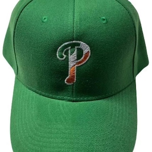 Könnte beinhalten: Grüne Baseballkappe mit einem weißen und orangefarbenen gestickten "P" auf der Vorderseite. Das "P" ist so gestaltet, dass es wie die irische Flagge aussieht.