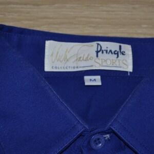 May include: A blue collared shirt with a white label that reads "Willie Faldo Collection Pringle Sports" and a size "M" label.