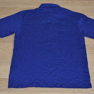 May include: A solid blue short-sleeved polo shirt.