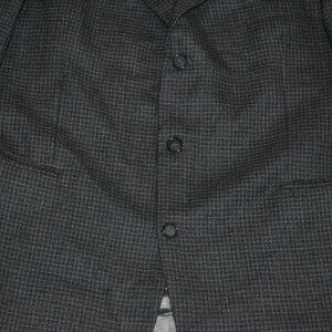 May include: A dark gray blazer with a subtle checkered pattern and a single button closure.