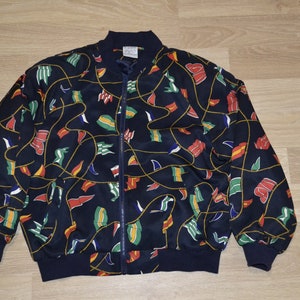 May include: A navy blue bomber jacket with a colorful pattern of flags and ropes. The jacket has a zipper closure and ribbed cuffs and hem.