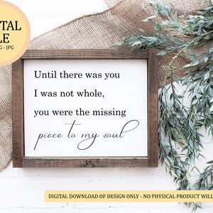 May include: A framed wooden sign with the text "Until there was you, I was not whole, you were the missing piece to my soul." The sign is surrounded by greenery and burlap. The top left corner has a digital file logo.