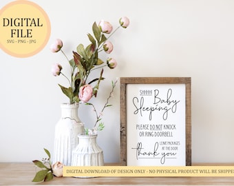 May include: A white sign with a brown wooden frame that reads "SHHHH! Baby Sleeping. Please do not knock or ring doorbell. Leave packages at the door. Thank you." The sign is sitting on a wooden surface with a bouquet of pink flowers in a white vase.