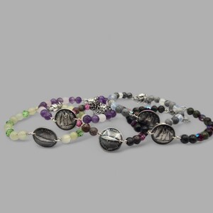 May include: A collection of beaded bracelets with silver coin details. The bracelets feature beads in various colours, including green, purple, and black. The coins are marked "10 CENTS" and "CANADA 1967-1967".