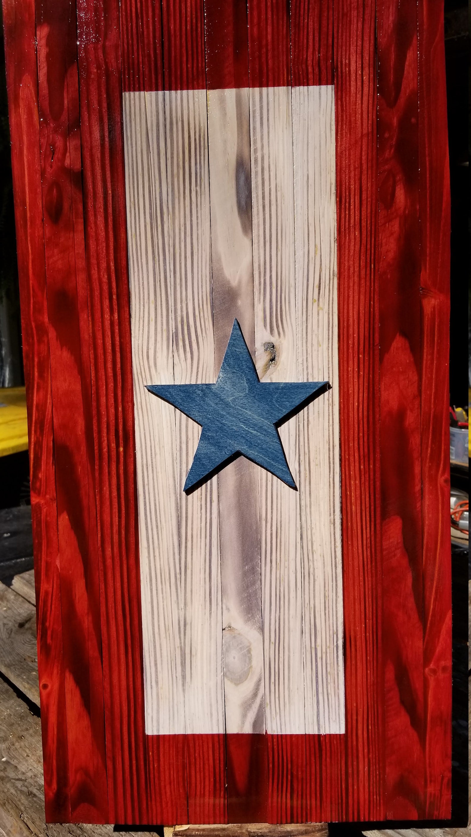 Deployment flag: rustic rectangle with red on the outside, neutral beige in the middle and blue star in the center. 