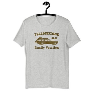 May include: A heather grey t-shirt with a brown graphic of a vintage station wagon with luggage on the roof. The text "Yellowstone 2021 Family Vacation" is printed below the car.