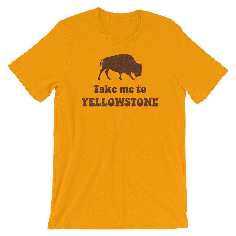 May include: Yellow T-shirt with a brown silhouette of a bison and the text "Take me to Yellowstone" in brown.