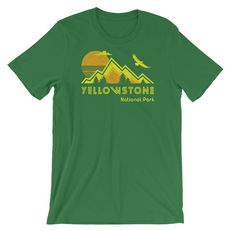 May include: A green t-shirt with a yellow graphic of mountains, a sun, and a bird. The text "Yellowstone National Park" is printed in yellow below the graphic.