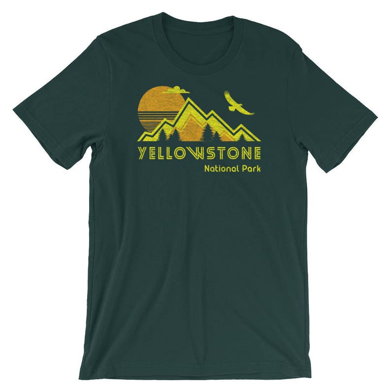May include: A dark green t-shirt with a yellow and orange graphic of mountains, a sun, and a bird. The text "Yellowstone National Park" is printed in yellow below the graphic.