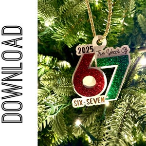 Puede incluir: Adorno navideño con el texto "2025 The Year Of 67 Six-Seven". El adorno tiene un "6" rojo brillante y un "7" verde brillante. Cuelga de un cordón dorado.
