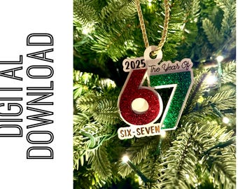 May include: Christmas tree ornament with the text "2025 The Year Of 67 Six-Seven". The ornament has a red glitter "6" and a green glitter "7". It hangs from a gold cord.