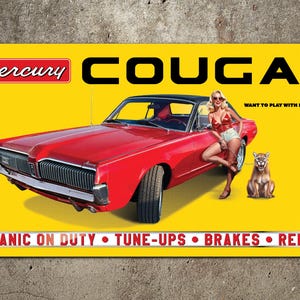 May include: Yellow banner featuring a red Mercury Cougar car with a woman and a cougar. The banner includes the text "Mercury COUGAR" and "MECHANIC ON DUTY • TUNE-UPS • BRAKES • REPAIRS".