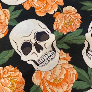 Puede incluir: Patrón repetitivo con calaveras blanquecinas, peonías naranjas y hojas verdes sobre fondo negro. El diseño floral y de calaveras crea una estética única y llamativa, adecuada para tela o papel pintado.