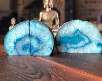 May include: A pair of blue agate bookends with a white and blue pattern. The bookends are made of natural stone and have a unique, organic shape.
