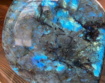 May include: A large, polished, heart-shaped piece of labradorite with iridescent blue and green hues.