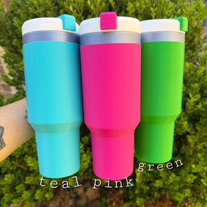 May include: Three insulated tumblers in teal, pink, and green. Each tumbler has a white lid with a colored accent and a silver band. The words "teal", "pink", and "green" are written below each tumbler.