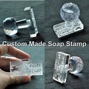 May include: Clear acrylic stamp with a crystal handle. The stamp reads "Soap Made By" with a shamrock design.