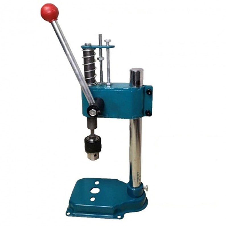 May include: A blue metal hand press with a red handle and a spring-loaded mechanism. The press has a base with three holes and a vertical post with a chuck at the top.