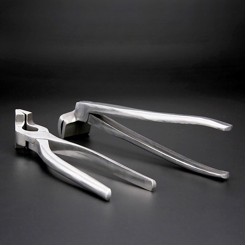 May include: Two silver metal pliers with long handles. The pliers are designed for bending metal.