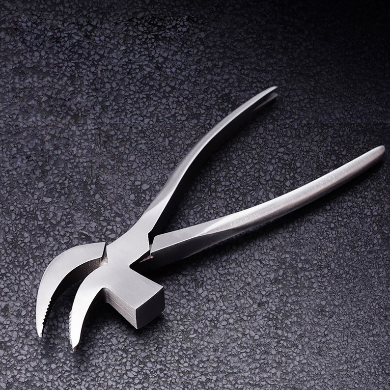 May include: A silver metal hammer with a curved claw and a serrated edge. The hammer is designed for pulling nails and is a tool for construction and DIY projects.