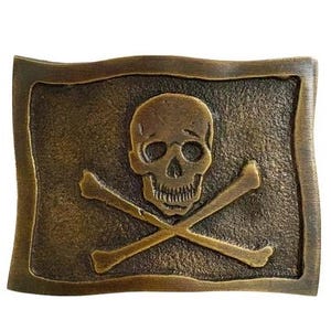 May include: A rectangular, antique brass belt buckle featuring a skull and crossbones design. The skull is centered above two crossed bones, all set against a textured background. The buckle has a weathered, vintage appearance.