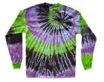 May include: A long-sleeved shirt with a tie-dye pattern in shades of purple, green, and black. The shirt has a spiral design.