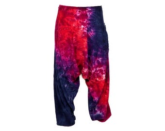 Peut inclure: Un pantalon tie-dye avec un motif rouge, violet et bleu. Le pantalon a une coupe ample et fluide et est fait d'un tissu doux et confortable.