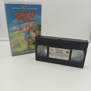 K&ouml;nnte beinhalten: Eine VHS-Kassette und ihre H&uuml;lle f&uuml;r den Zeichentrickfilm "Pippi Langstrumpf". Die H&uuml;lle ist blau mit dem Titel in Rot und Gelb. Die VHS-Kassette ist schwarz mit einem wei&szlig;en Etikett.