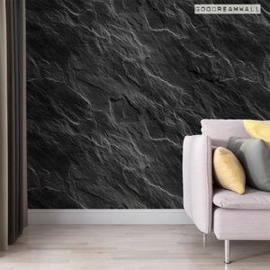 May include: A black and white textured wallpaper with a gray couch in the foreground. The wallpaper has a slate stone pattern. The couch is a light gray color and has a yellow pillow on it. The text "GOODREAMWALL" is in the upper right corner of the image.